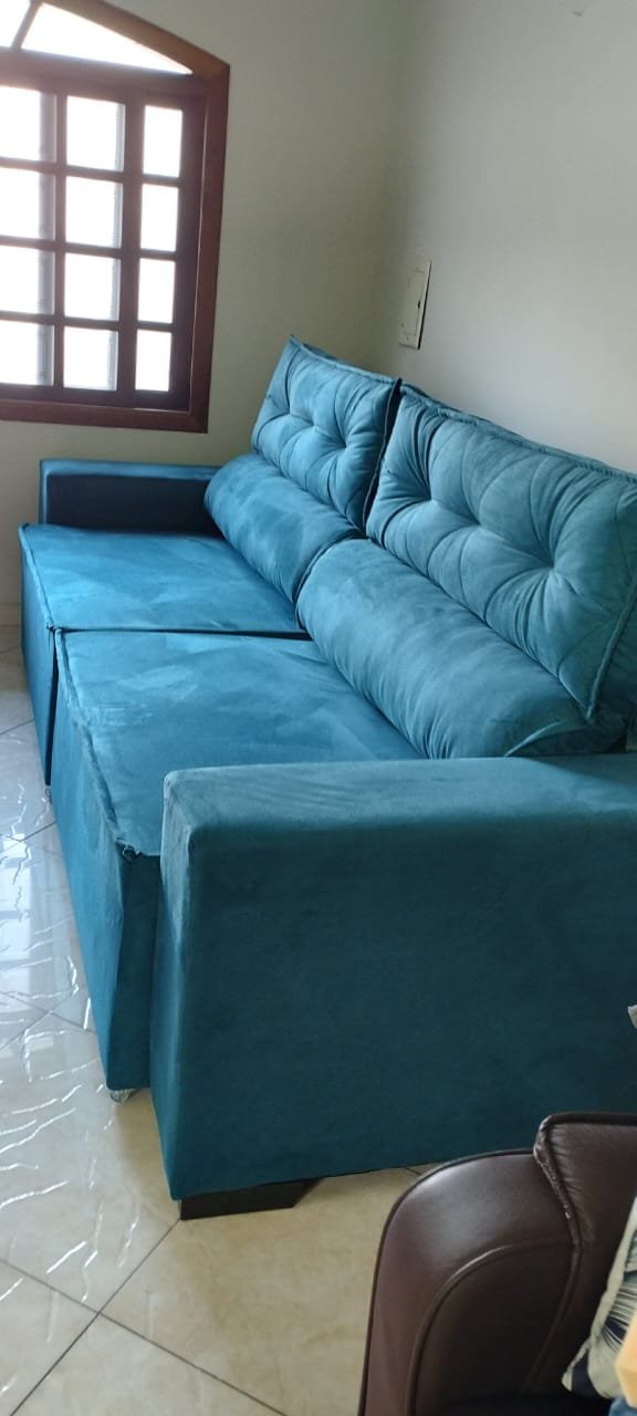 Sofá retrátil azul com encosto acolchoado